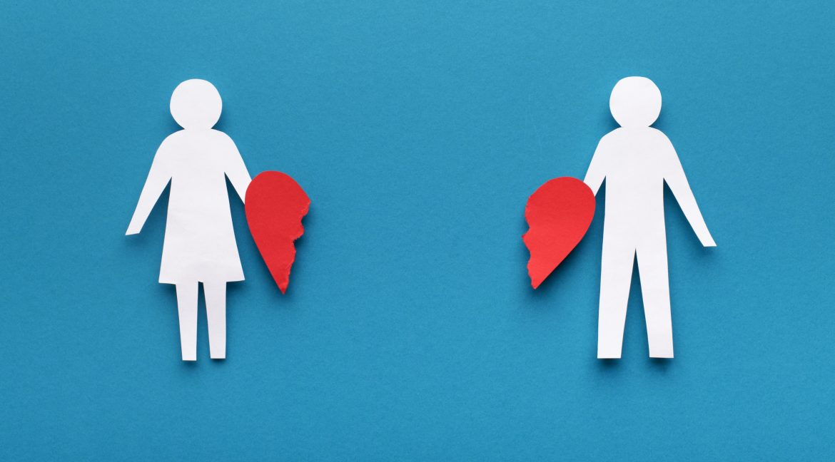 Papercut figures with broken heart on blue background