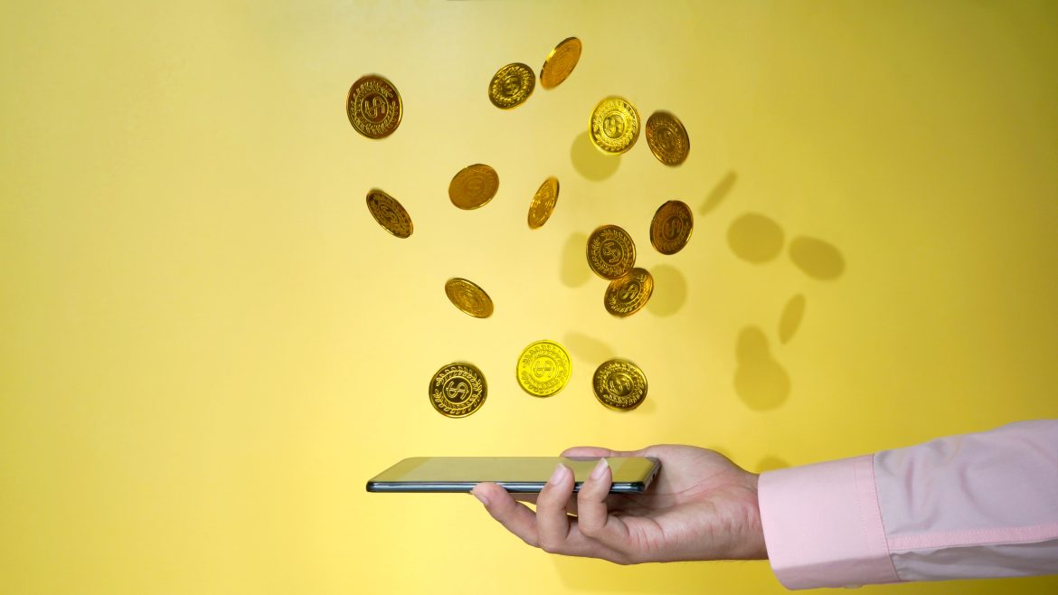 phone with gold coins dropping , financial and phone internet concept photo Lucky Charm for money
