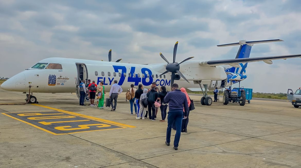 Passengers boarding a Fly748.com plane which offers cheaper flights to coast.